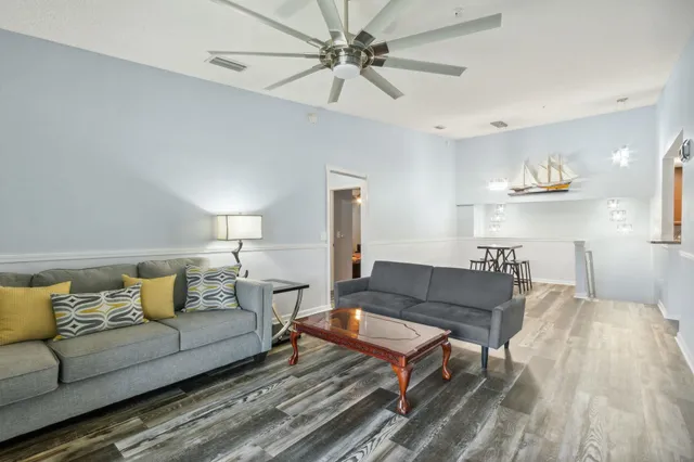 a living room with furniture and a wooden floor