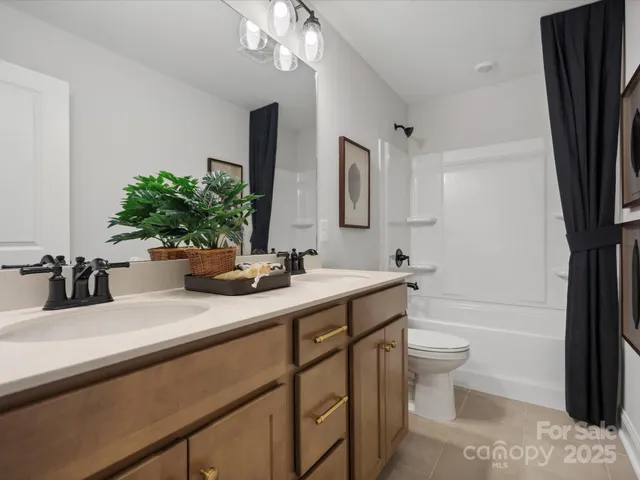 a bathroom with a sink a toilet a mirror and shower