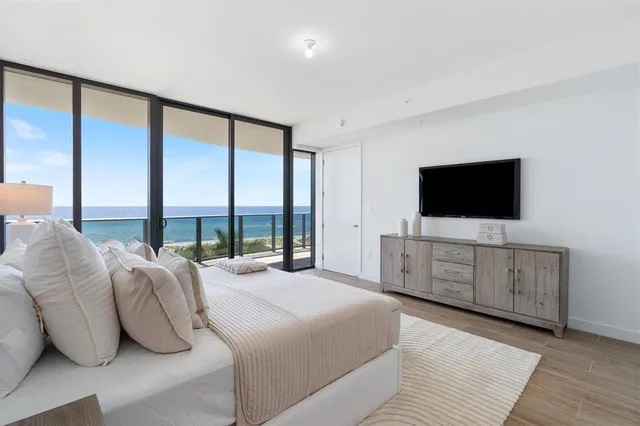 a bedroom with a large window and a flat screen tv