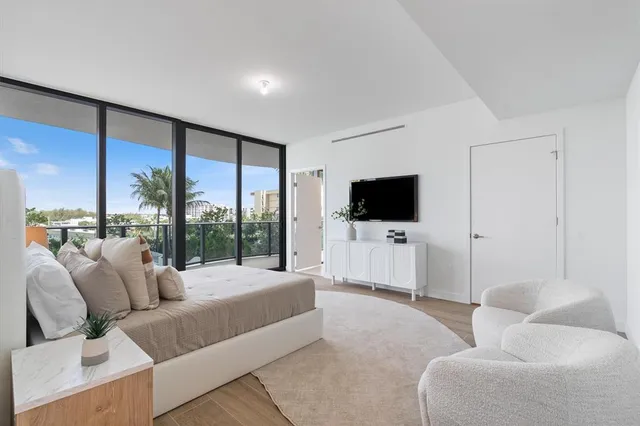 a living room with furniture a flat screen tv and a floor to ceiling window