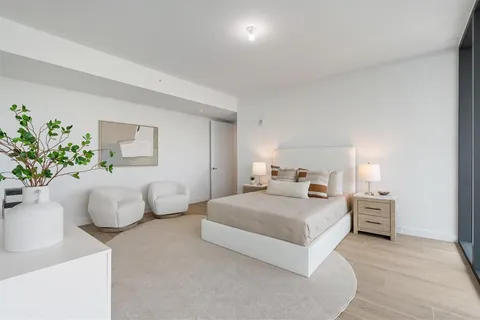 a bedroom with a bed and a potted plant