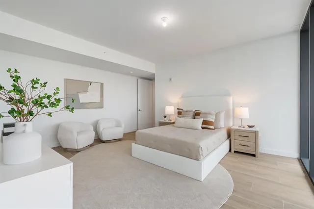 a bedroom with a bed and a potted plant