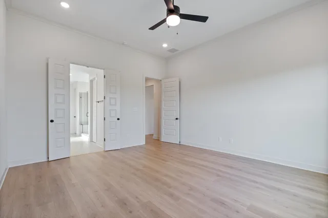 a view of an empty room with a chandelier fan