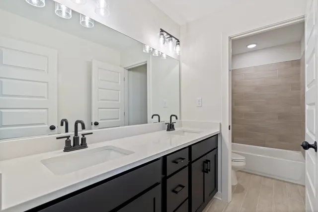 a white toilet and tub sitting next to a bathroom sink