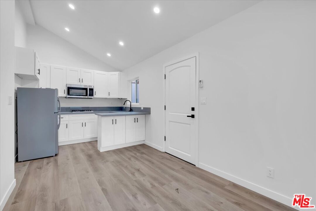 7421 Amigo Avenue Reseda, CA 91335 - Photo 4 of 10 a large kitchen with granite countertop a stove a sink and a refrigerator