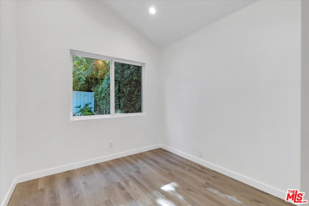 7421 Amigo Avenue Reseda, CA 91335 - Photo 9 of 10 a view of an empty room with wooden floor and a window