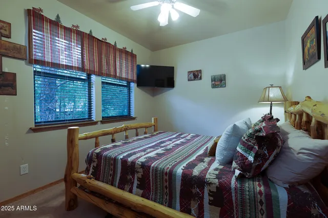 a bedroom with a bed a dresser a lamp and a window