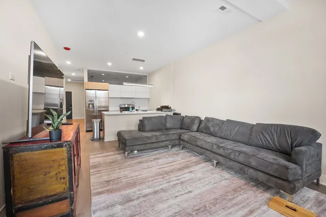 a living room with furniture and a view of kitchen