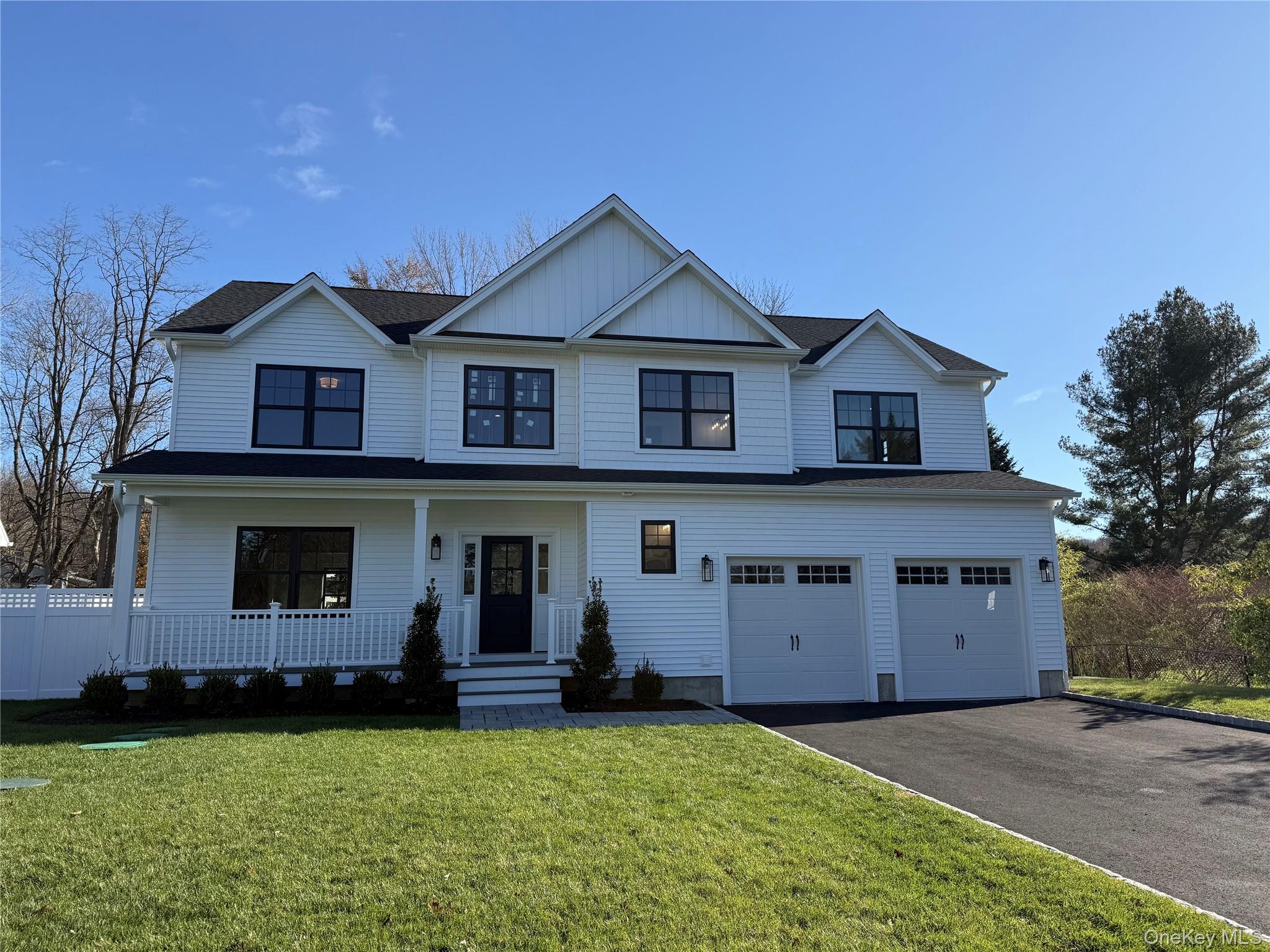40 North Woodhull Road Huntington, NY 11743 - Photo 3 of 3 Modern inspired farmhouse with board and batten siding, covered porch, driveway, and a garage