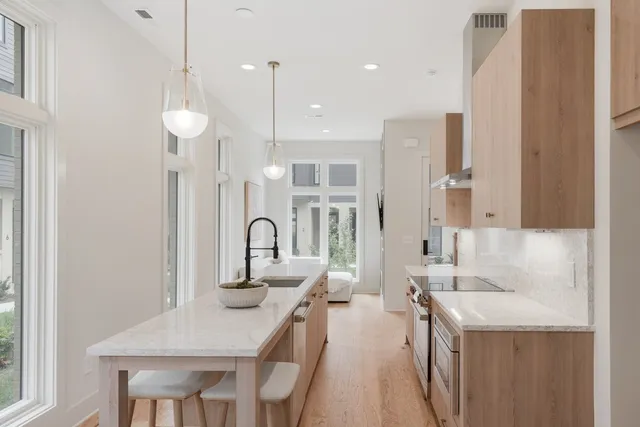 a kitchen with stainless steel appliances a table chairs and a refrigerator