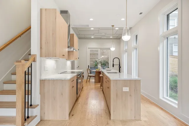 a large kitchen with stainless steel appliances kitchen island granite countertop a sink and cabinets