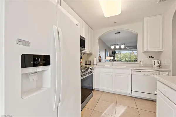 a kitchen with white cabinets and white appliances