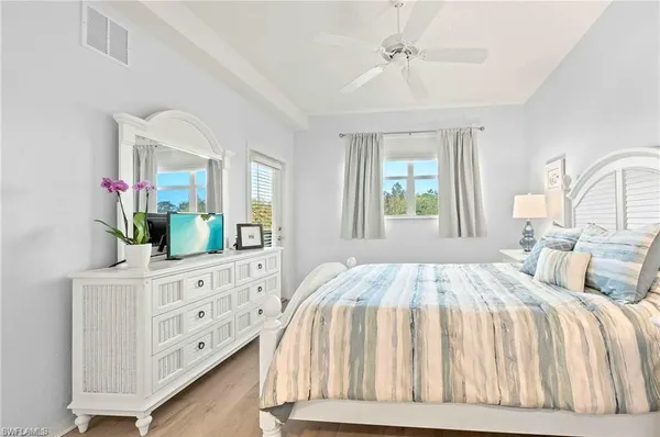 a bedroom with a bed a dresser and next to a window