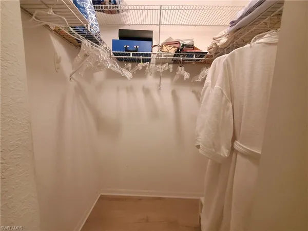 a view of walk in closet with clothes and shoes