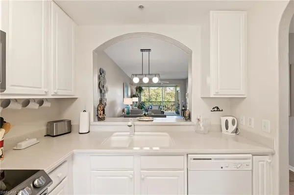 a kitchen with stainless steel appliances white cabinets and a window