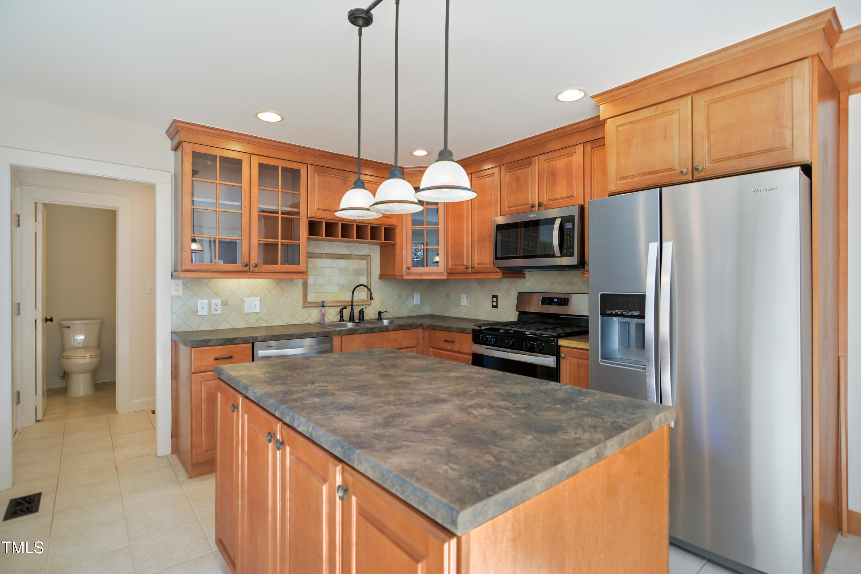 7216 Bluffside Court Raleigh, NC 27615 - Photo 6 of 22 a kitchen with stainless steel appliances granite countertop a sink refrigerator and microwave