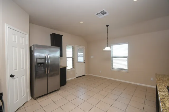 a view of an empty room with window and chandelier fan