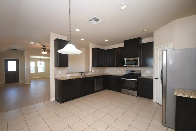 a kitchen with stainless steel appliances granite countertop a refrigerator and a sink