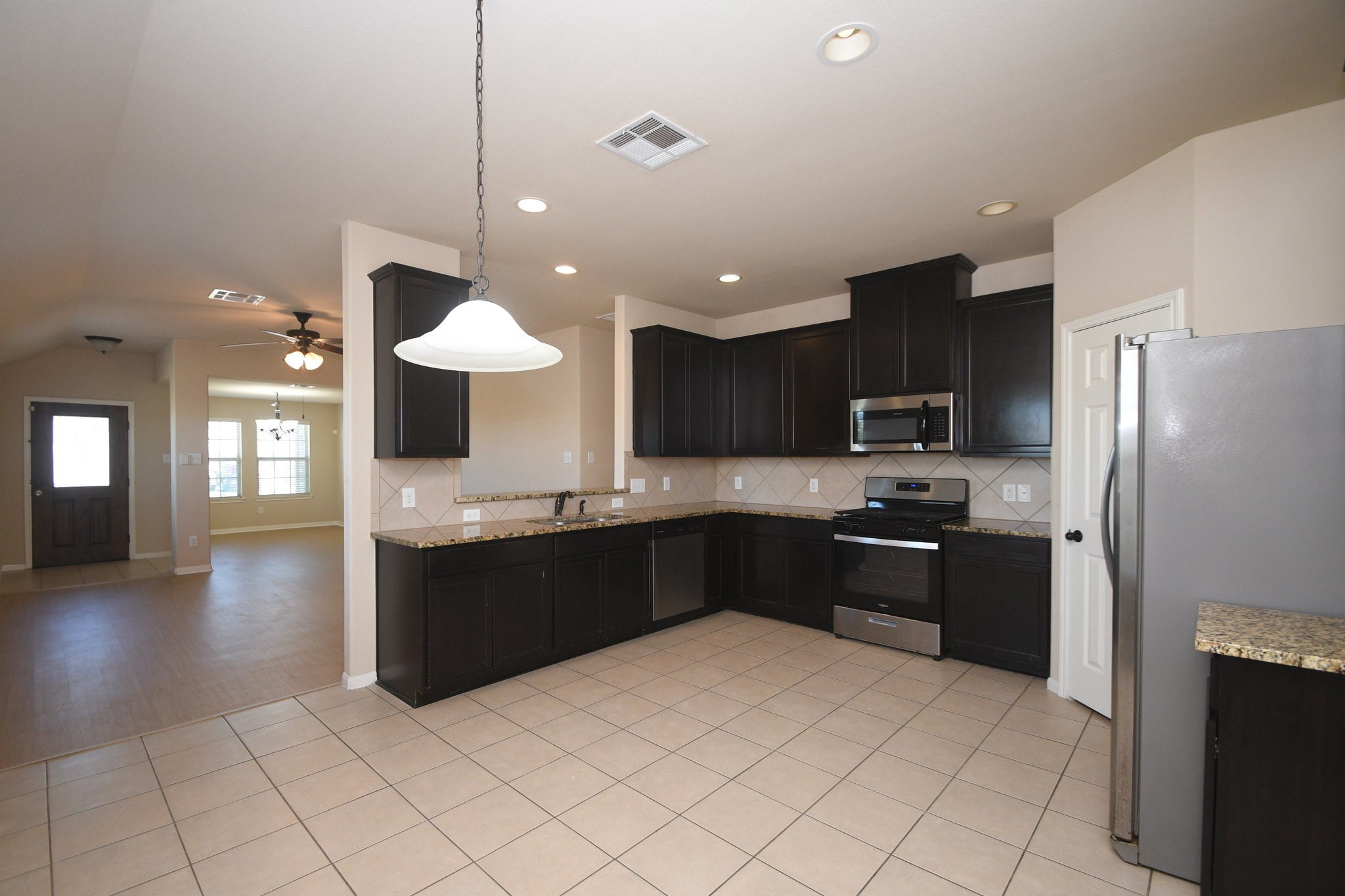 10015 Bitternut Hickory Lane Tomball, TX 77375 - Photo 13 of 36 a kitchen with stainless steel appliances granite countertop a refrigerator and a sink