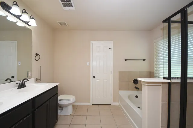 a bathroom with a sink a toilet a light fixture and a window