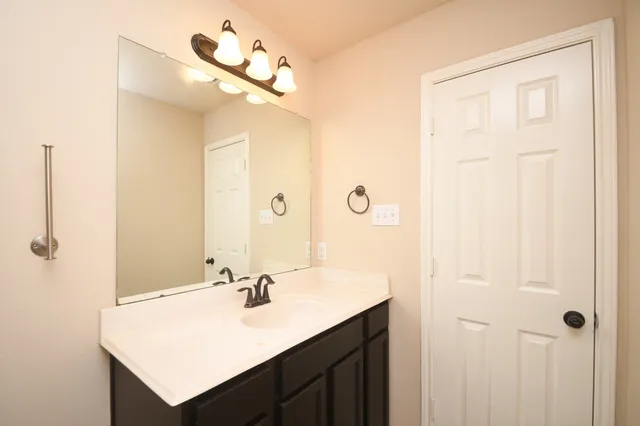 a bathroom with a sink vanity and a mirror