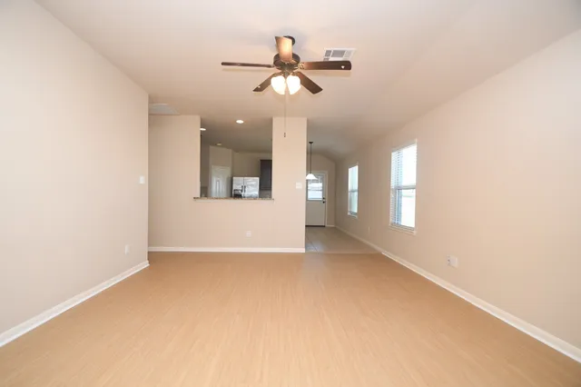 a view of a livingroom with a ceiling fan and window