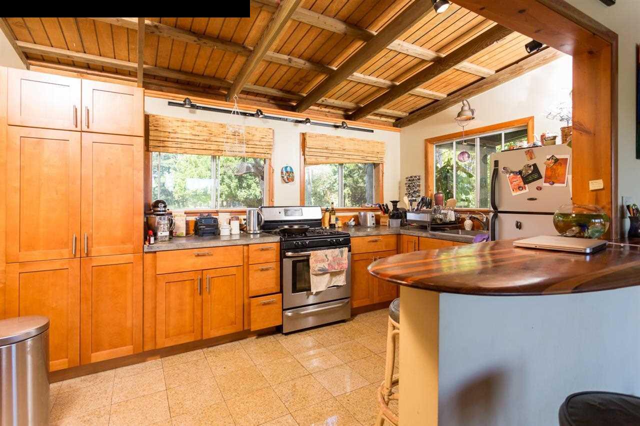 999 Hog Back Road Haiku, HI 96708 - Photo 8 of 29 a kitchen with stainless steel appliances granite countertop a sink and a large window