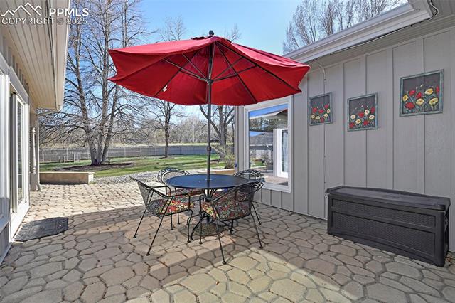 2421 Strickler Road Colorado Springs, CO 80906 - Photo 14 of 44 View of patio featuring fence and outdoor dining area