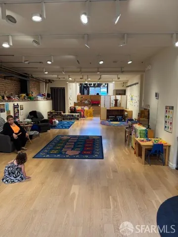 a living room filled with furniture and kitchen view