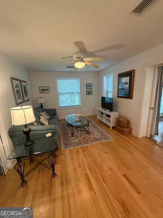 a living room with furniture and a wooden floor