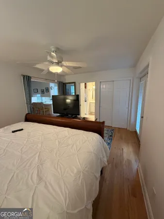 a bedroom with a bed and a flat tv screen on dresser