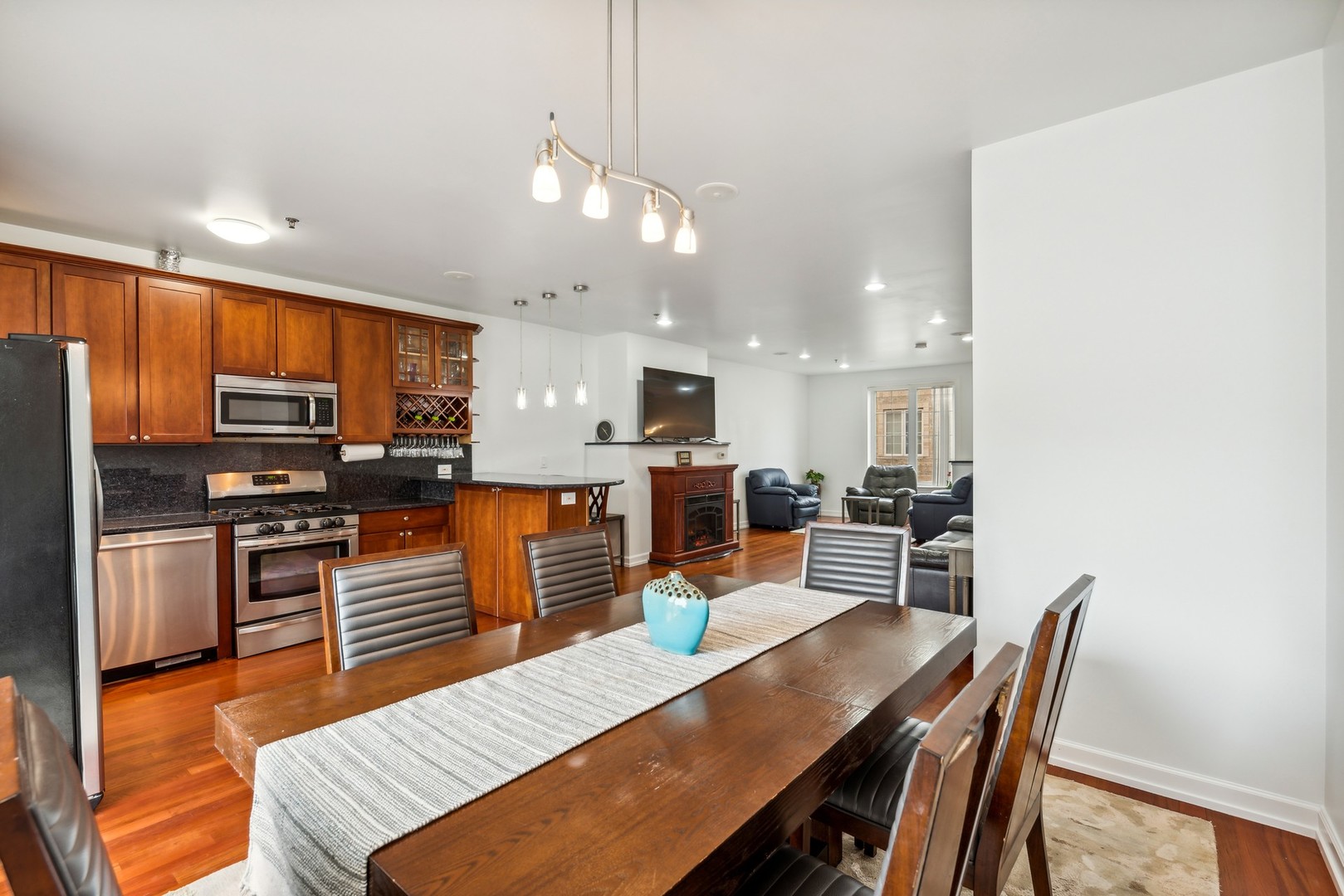 183 East River Road, Unit D2 Des Plaines, IL 60016 - Photo 11 of 42 a view of a dining room with furniture a kitchen and chandelier