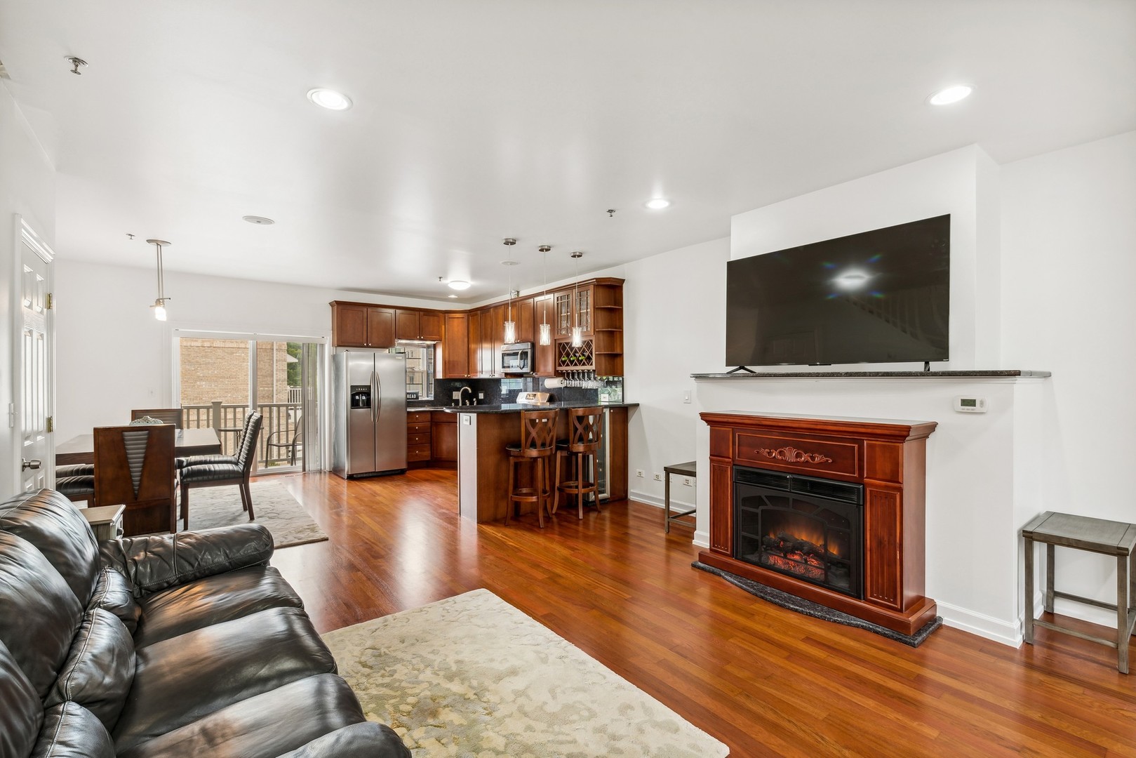 183 East River Road, Unit D2 Des Plaines, IL 60016 - Photo 2 of 42 a living room with furniture a fireplace and a flat screen tv