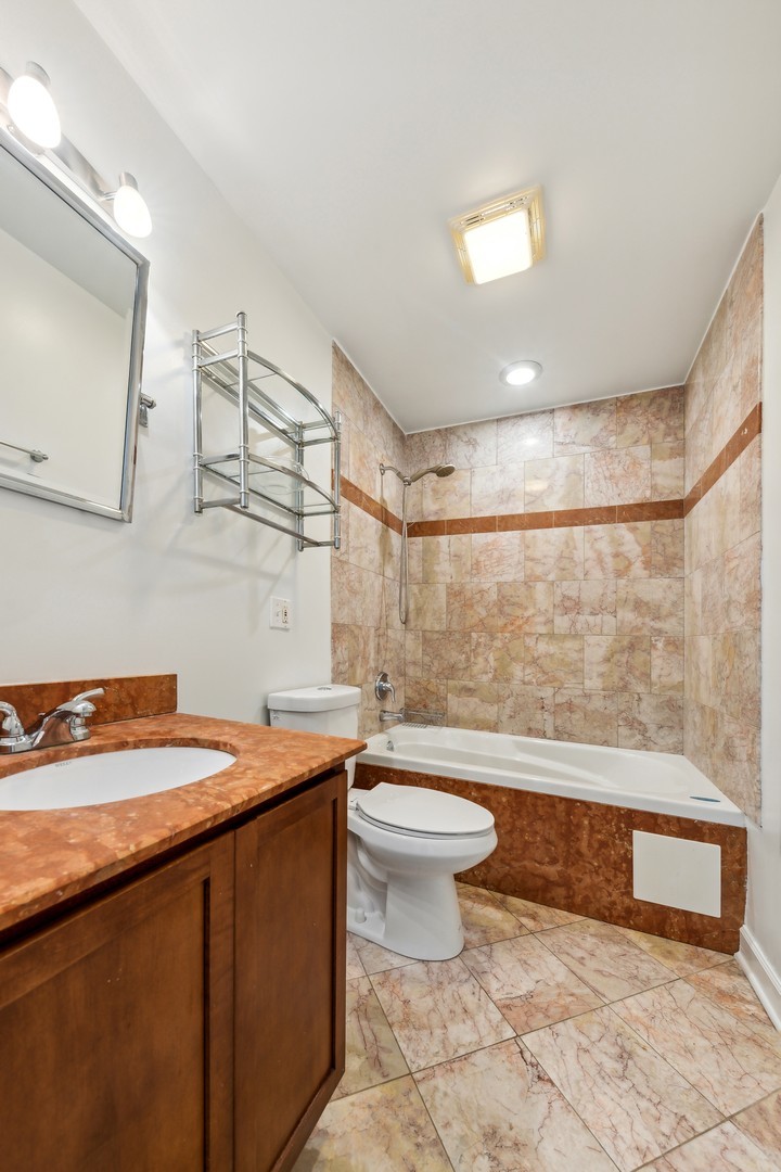 183 East River Road, Unit D2 Des Plaines, IL 60016 - Photo 30 of 42 a bathroom with a sink a toilet and mirror