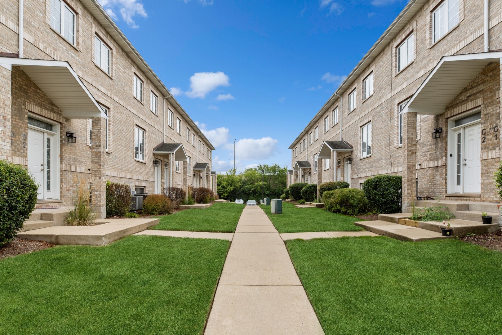 183 East River Road, Unit D2 Des Plaines, IL 60016 - Photo 38 of 42 a view of a white apartments with a big yard and plants