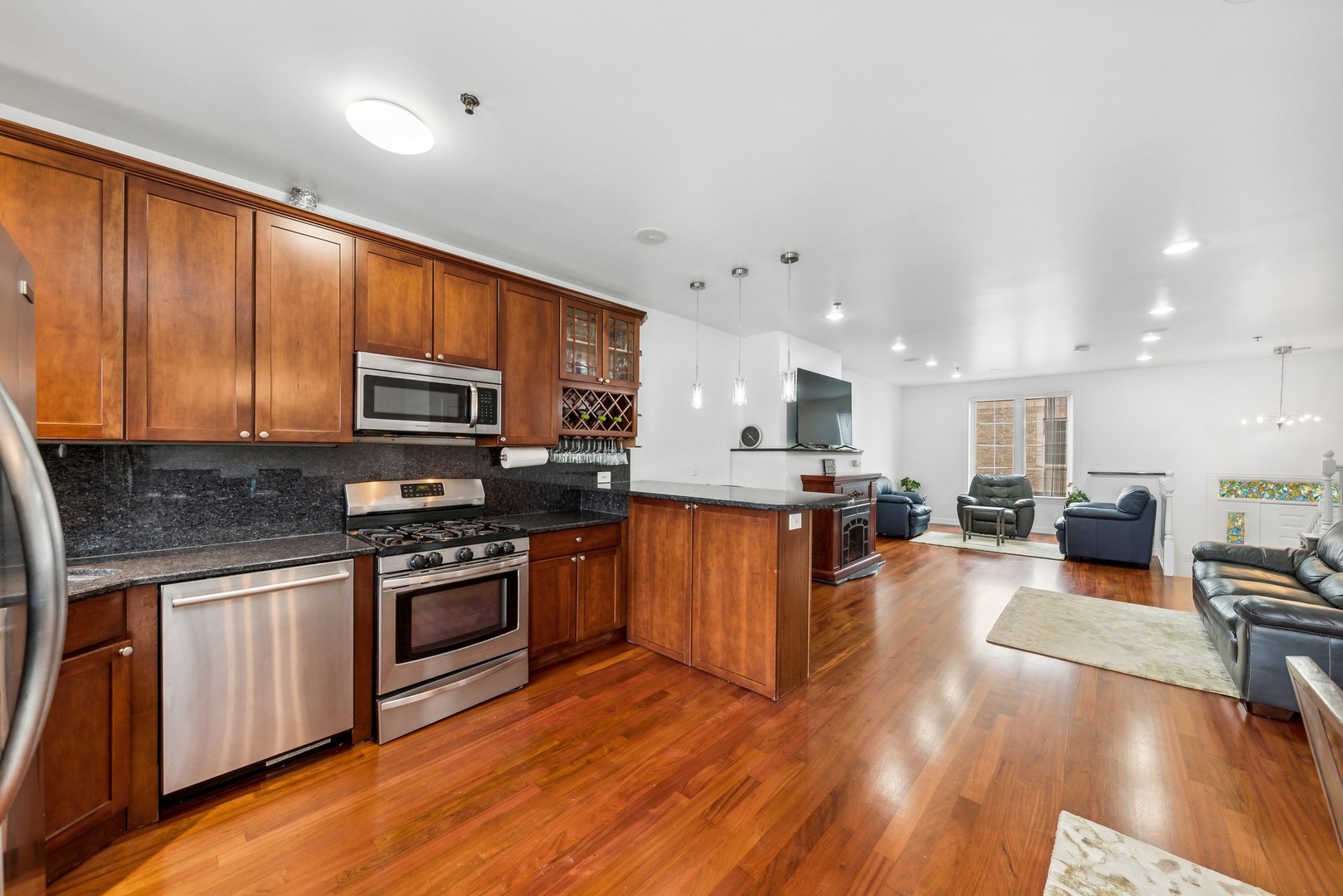 183 East River Road, Unit D2 Des Plaines, IL 60016 - Photo 6 of 42 a large kitchen with stainless steel appliances granite countertop a stove top oven a sink dishwasher a dining table and chairs with wooden floor