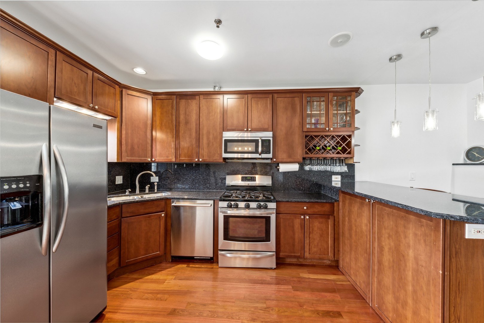 183 East River Road, Unit D2 Des Plaines, IL 60016 - Photo 7 of 42 a kitchen with stainless steel appliances granite countertop a refrigerator a stove and a sink with wooden cabinets