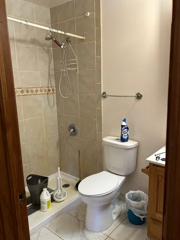 a white toilet sitting next to a bathroom sink and a shower