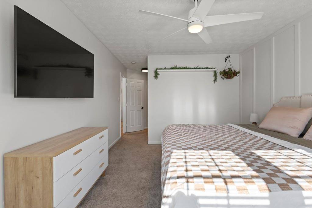 970 Sidney Marcus Boulevard Northeast, Unit 2408 Atlanta, GA 30324 - Photo 14 of 27 a bedroom with a bed and a chandelier