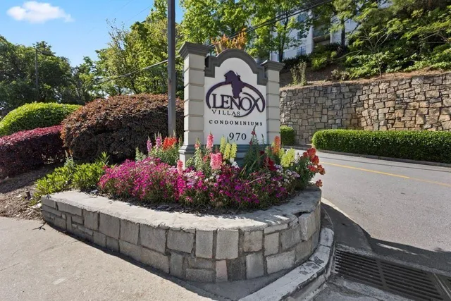 a view of a sign board with buildings in the background