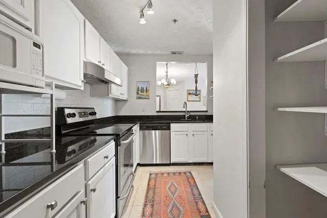 a kitchen with stainless steel appliances granite countertop a sink and a stove