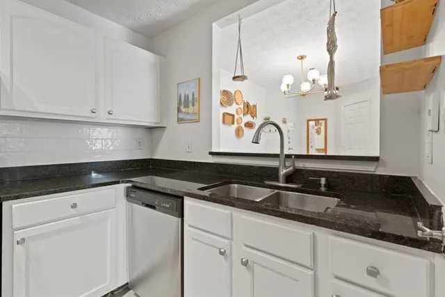 a kitchen with granite countertop a sink and cabinets