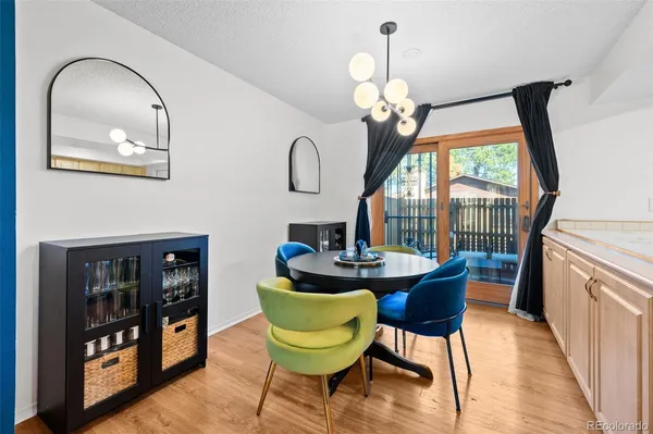 a view of a dining room with furniture a chandelier and wooden floor