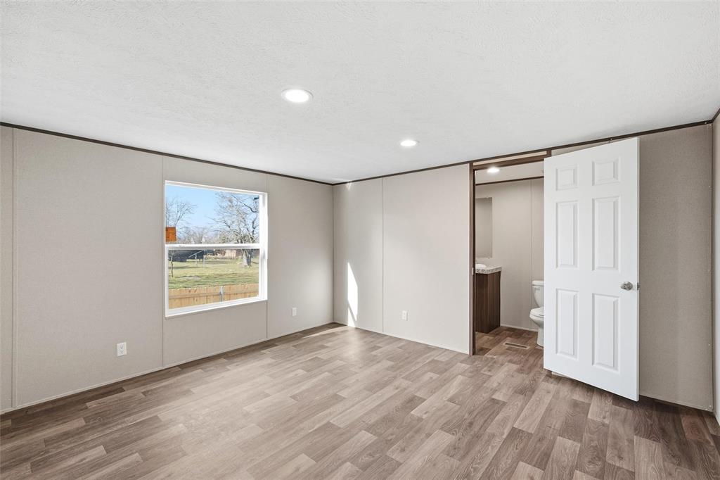 618 East 6th Street, Unit B Blum, TX 76627 - Photo 12 of 24 a view of an empty room with wooden floor and a window