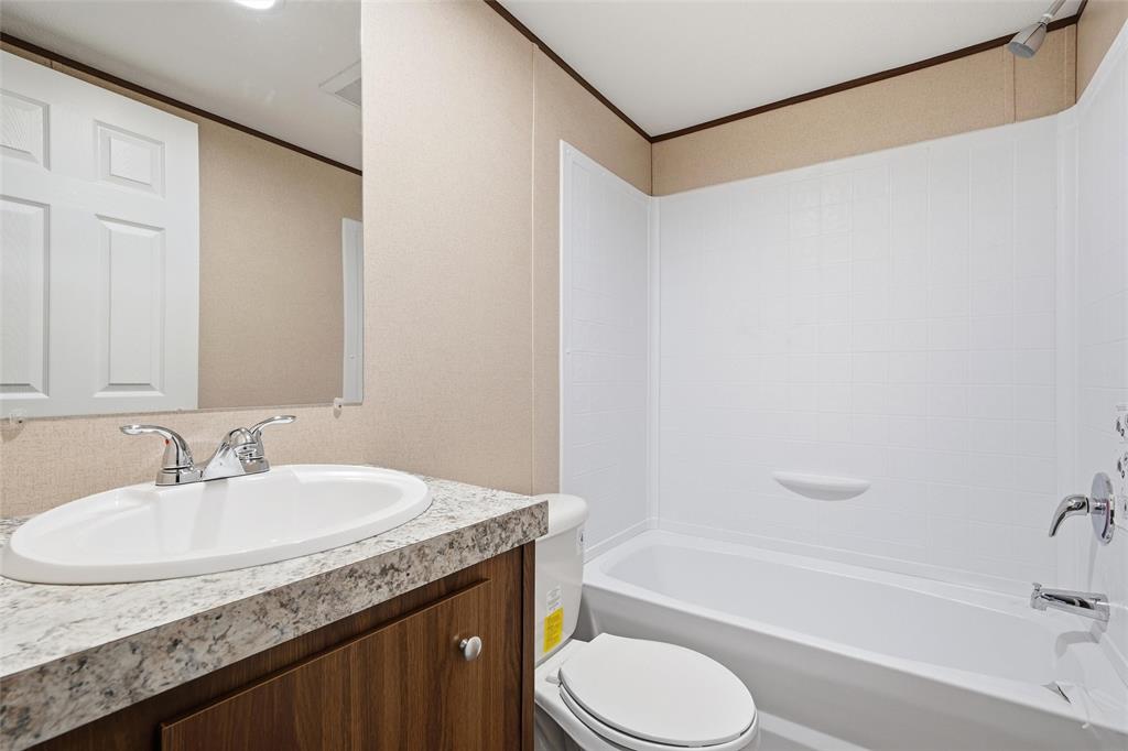 618 East 6th Street, Unit B Blum, TX 76627 - Photo 18 of 24 a bathroom with a granite countertop sink toilet and shower