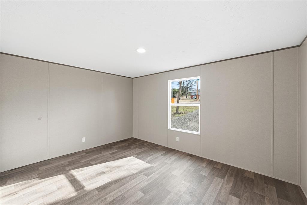 618 East 6th Street, Unit B Blum, TX 76627 - Photo 19 of 24 an empty room with wooden floor and windows