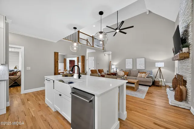 a view of living room with kitchen island stainless steel appliances wooden floor and living room view