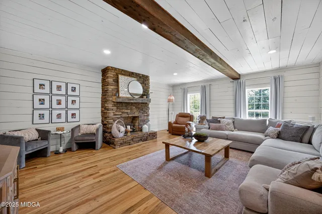 a living room with furniture a fireplace and a large window