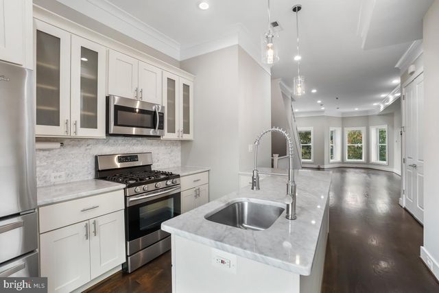 a kitchen with a sink stove and microwave