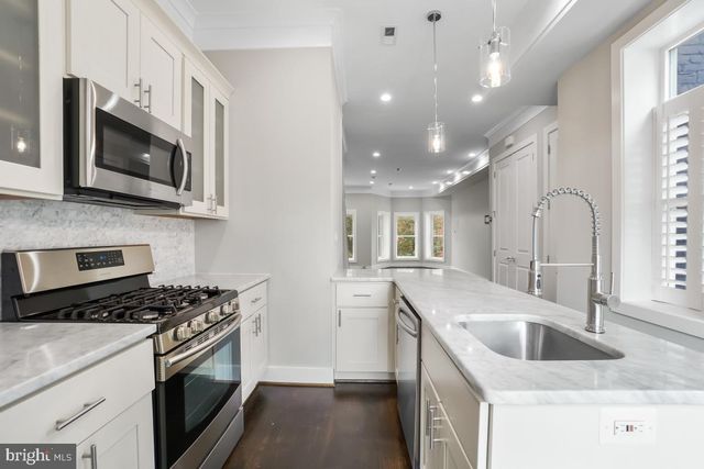 a kitchen with stainless steel appliances granite countertop a sink stove and microwave